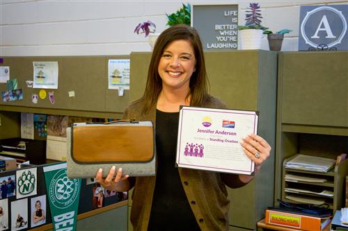 Jennifer Anderson smiling with Standing Ovation certificate and blanket prize