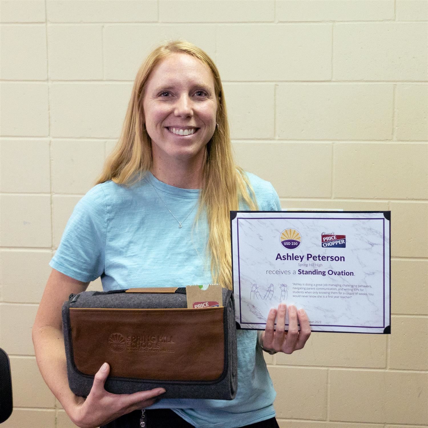 Ashley Peterson smiling with Standing Ovation certificate and blanket prize