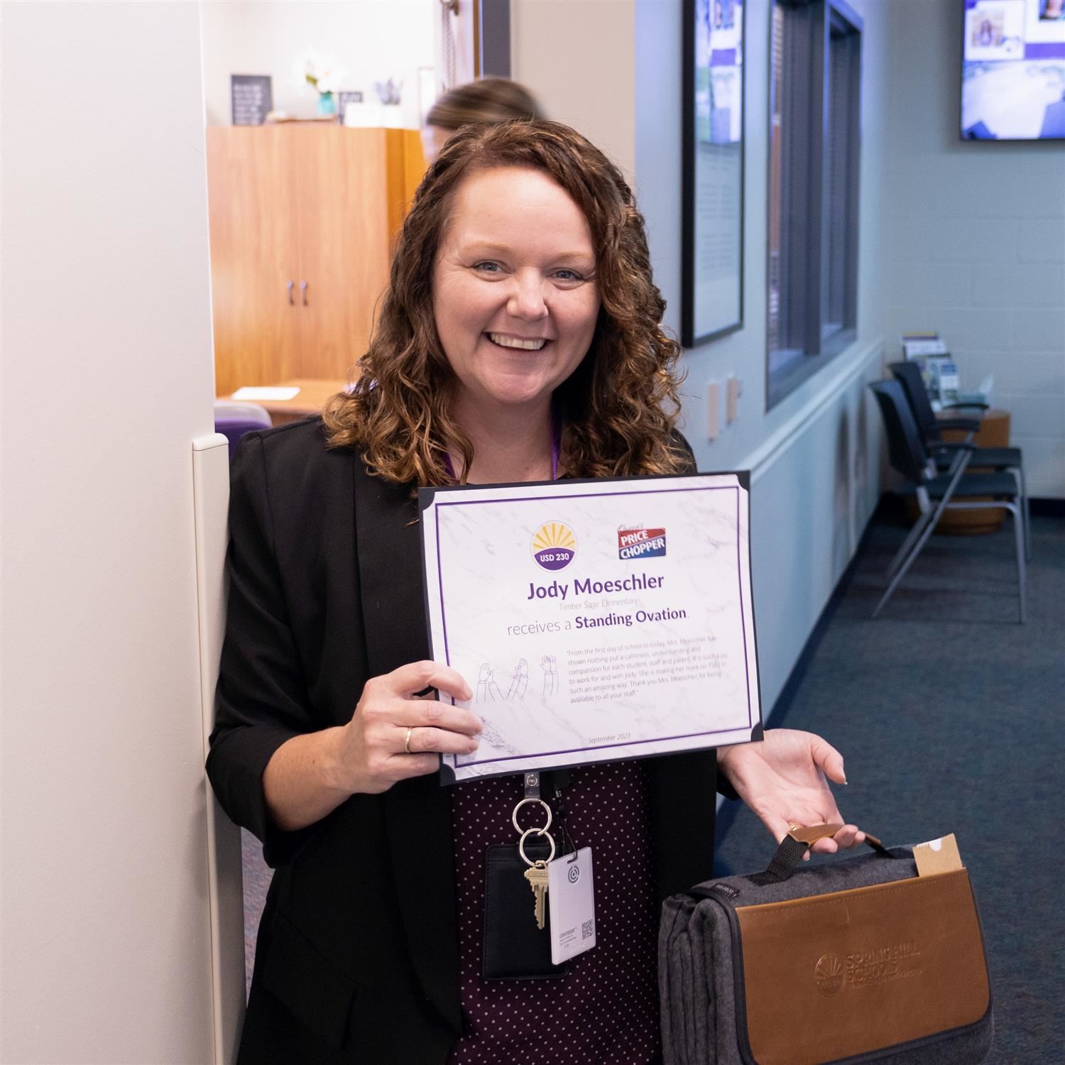 Jody Moeschler smiling with Standing Ovation certificate and blanket prize