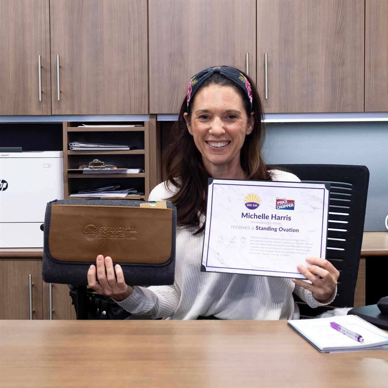 Michelle Harris smiling with Standing Ovation certificate and blanket prize