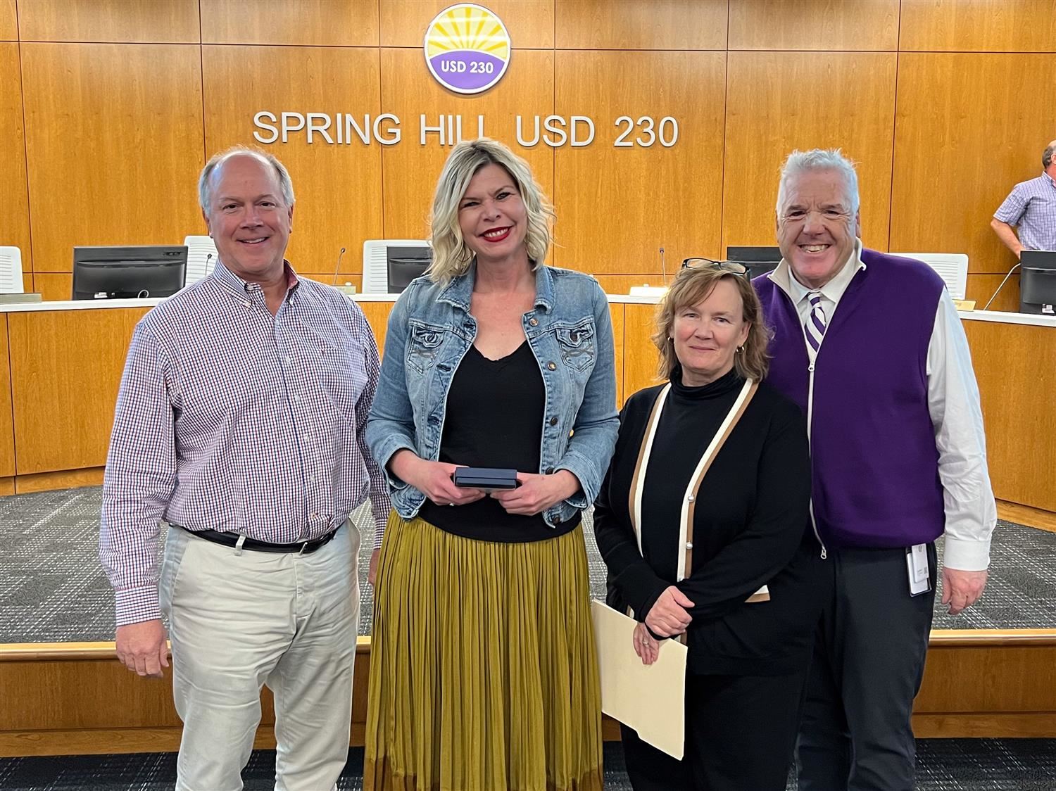 Michelle Seichepine smiling with Core Value Award with district leadership