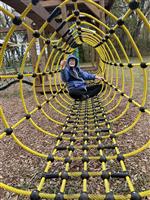 Student enjoys time on the rope web.
