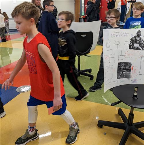 Student posing as Maurice Greene during the 4th Grade Famous Kansan Wuax Museum