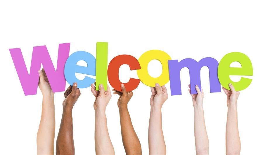  hands holding up letters spelling welcome