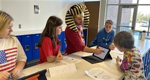Students work at activity station with school materials.
