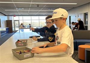 Students work at activity station with school materials.