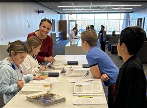 Students work at activity station with school materials.